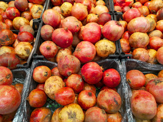 Ripe pomegranates on a shelf in a store