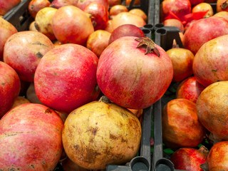 Ripe pomegranates on a shelf in a store