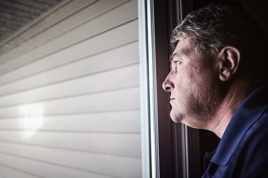 Middle Aged Man Looking Out The Window, Depression And Loneliness Concept