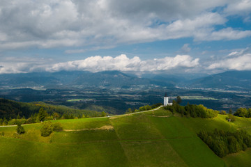 Aerial view of a white church on the mountain top, The Church Of St Primoz in Slovenia