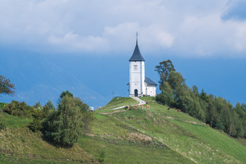 Fototapeta na wymiar Aerial view of a white church on the mountain top, The Church Of St Primoz in Slovenia