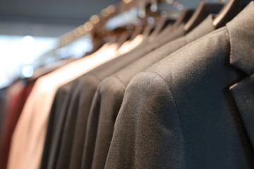 Closeup of dark gray man's suit hanging on hanger  in shopping store.