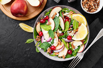 Homemade salad with fresh baby spinach, red apple, cranberry, walnuts and feta cheese.