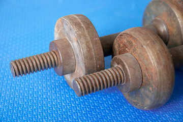old metal rusty dumbbells on a blue background