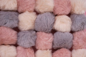 Pompons fur background. Set of fluffy gray, pink, beige pompons .  texture of the pompons. Fluffy  background in pastel colors.