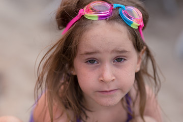 A girl is playing in the sand at a California beach.