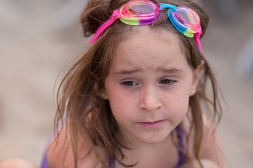 A girl is playing in the sand at a California beach.