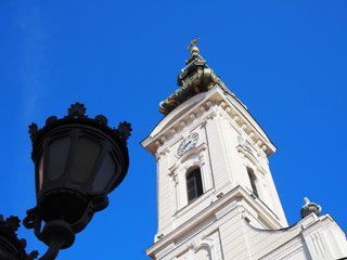 Fototapeta na wymiar church tower in sunshine against blue sky