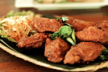 fired chicken wings with some lime leaf on top. 