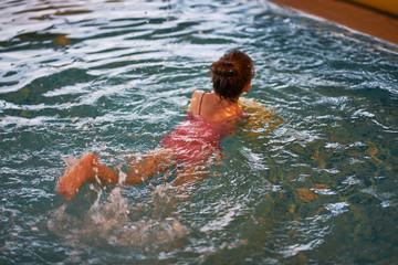 Adorable little girl playing and swimming in pool on holidays