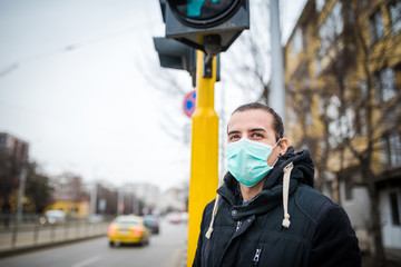 Young man with a medical face mask outdoor photo.Air pollution/ coronavirus protection concept.