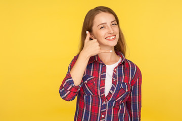 Call me! Portrait of sweet lovely beautiful girl in checkered shirt doing telephone gesture near...