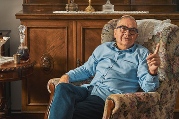 Senior Jew sitting in armchair in traditional home 