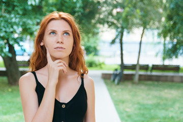 The concept of problem of choice. Pensive girl in park, copyspace.
