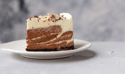 A piece of homemade raw chocolate cheesecake or mousse cake on white plate