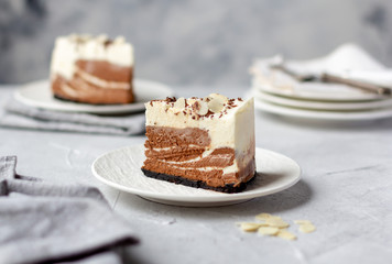 A piece of homemade raw chocolate cheesecake or mousse cake on white plate