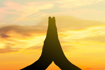 Praying hands on sky background
