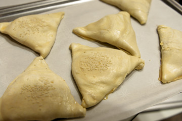 Triangular pies sprinkled with sesame seeds.