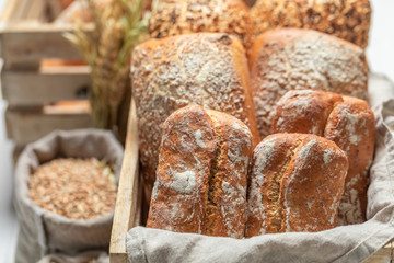 Rustic rolls with ears and grains in wooden box