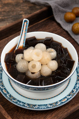 Black Grass Jelly Mesona chinensis, vegetable jelly, black in color, eaten with sugar. Pieces of grass jelly cut in bowl with colorful fruits on top (known as chaokuai, suong sao )