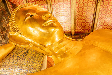 The Reclining Buddha of the reign of King Rama III. This is the largest and most beautiful piece of fine arts of a Buddha image in a reclining position found in Wat Pho, Bangkok, Thailand © chocobluesky19