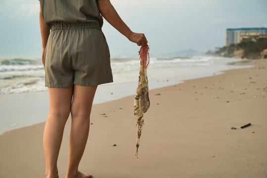 Young lady collected sea plastic garbage from the sea on a beach. Save the earth concept.