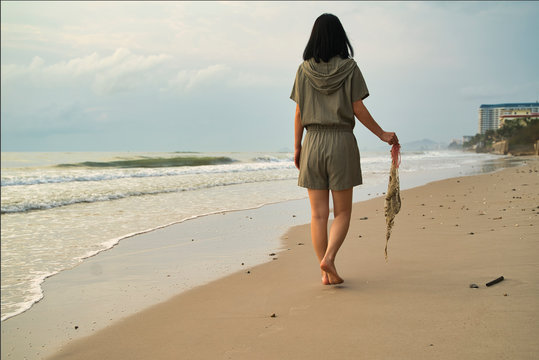 Young lady collected sea plastic garbage from the sea on a beach. Save the earth concept.
