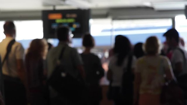 People stand in line to board flight at airport terminal