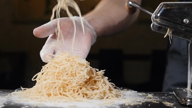 Chef holding in hands raw pasta. Making homemade fresh pasta. traditional italian recipe. Cooking food of italian cuisine. spaghetti pasta with flour in restaurant kitchen shot in slow motion. Full hd