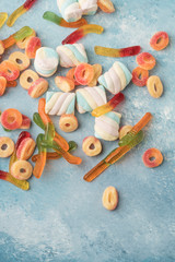 colorful jelly candies and marshmallow candy on a blue background