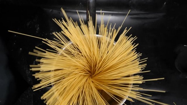 Top view on throwing spaghetti pasta into boiling water. Overhead shot. Shot with high speed camera, Slow Motion. Spaghetti in pan as circle shape . Magic food video video. Full hd