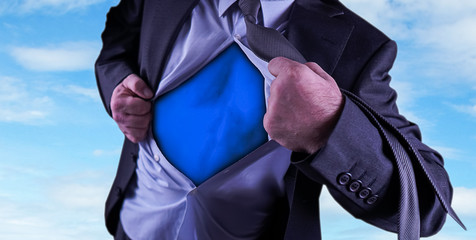 Superhero, young businessman tearing his shirt off isolated on dark background with copy space