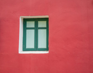 green frame of window on the old red cement wall