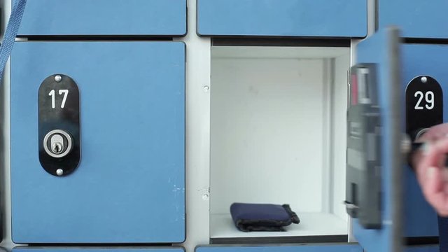 A person opens a safe locker with key, takes out wallet, close up