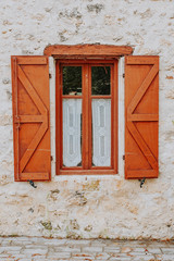 Obraz premium Old typical Mediterranean house with ocher stucco wall and closed wooden shutters