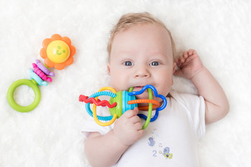 four-month-old boy chewing a rattle