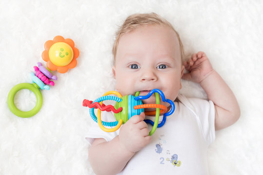 four-month-old boy chewing a rattle