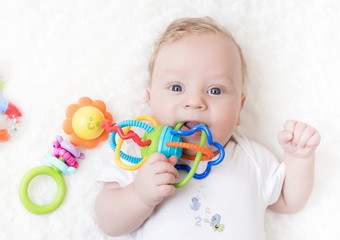 four-month-old boy chewing a rattle