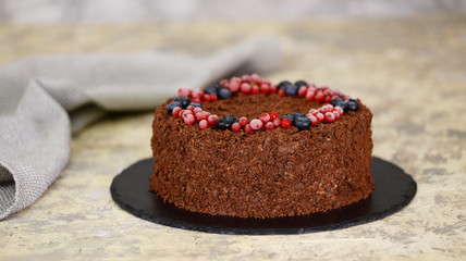 Russian chocolate cake Napoleon with berries and sprinkled with crumbs.
