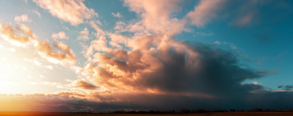 sunset panorama with large clouds on a background of blue sky