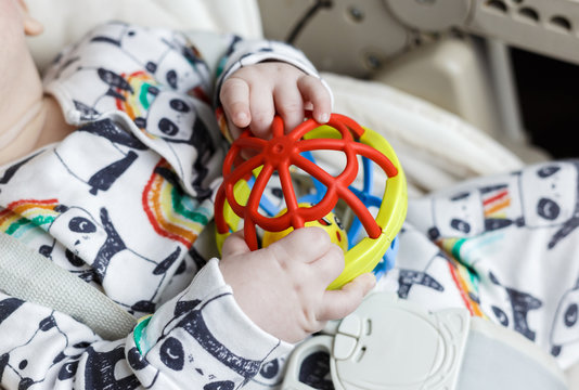 five-month-old blond boy with a toy in his hands