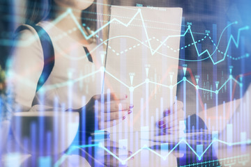 Double exposure of hands making notes with forex chart huds. Stock market concept.