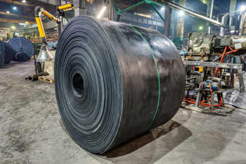 Large and heavy roll of conveyor belt.