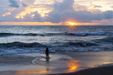 little boy near the ocean at sunset