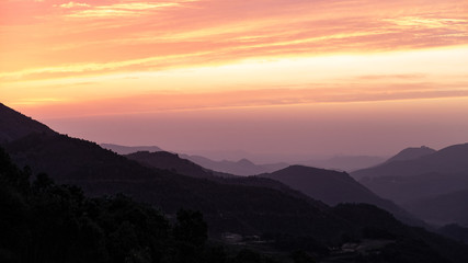 Fototapeta na wymiar Orange clouds on a mountain landscape sunset sky