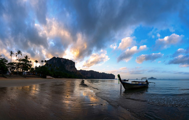 Traditional long-tail boat on the beach in Thailand at sunset