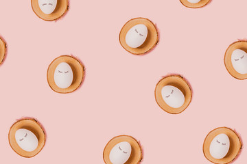 Happy Easter. White eggs with painted eyes on wooden trays on a pink background. Flat lay, top view, copy space.