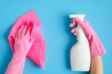 House cleaning service and housekeeping concept. Hands in yellow rubber gloves holding pink rag and...
