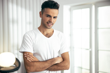 Smiling young man is posing in room