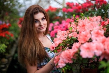 young girl admires blooming azaleas in a botanical garden. Closeup of butiful girl.